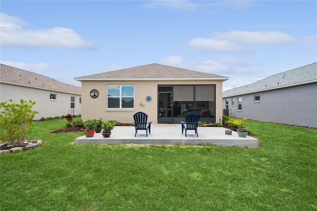 rear view of house featuring a lawn and a patio