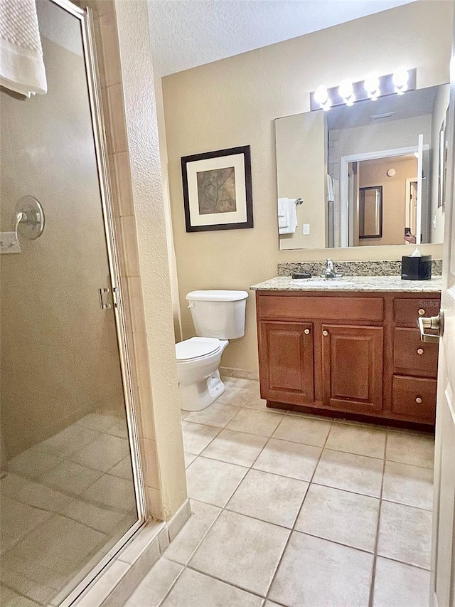 bathroom featuring a textured ceiling, tile floors, a shower with door, vanity, and toilet