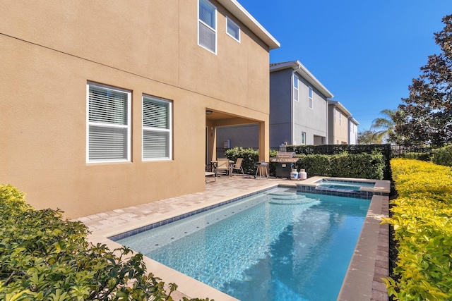 view of pool with an in ground hot tub and a patio area