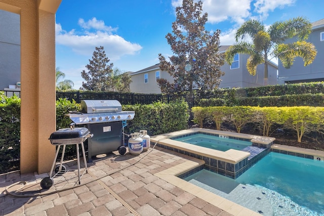 view of swimming pool featuring a patio, an in ground hot tub, and a grill