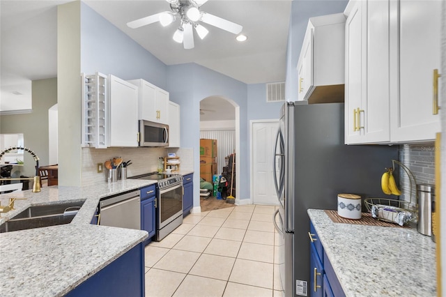 kitchen with blue cabinetry, white cabinets, and stainless steel appliances