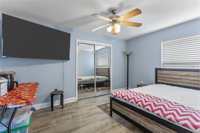 bedroom featuring hardwood / wood-style flooring, ceiling fan, and a closet