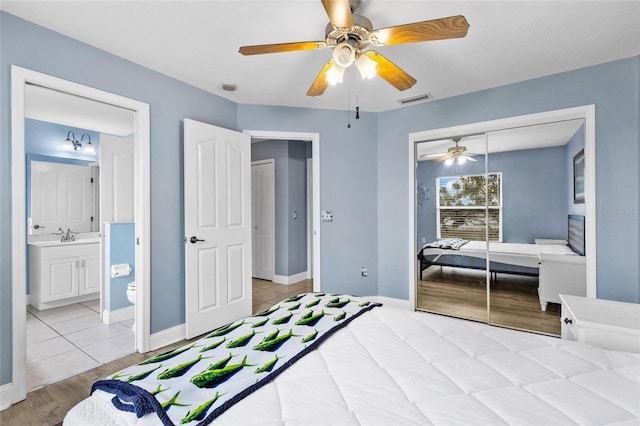 bedroom with ceiling fan, light hardwood / wood-style floors, connected bathroom, and a closet