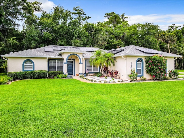 single story home featuring solar panels and a front lawn