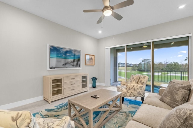 living area with a ceiling fan, recessed lighting, light wood-style flooring, and baseboards