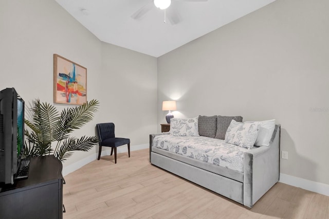 living area with light wood-type flooring, ceiling fan, and baseboards