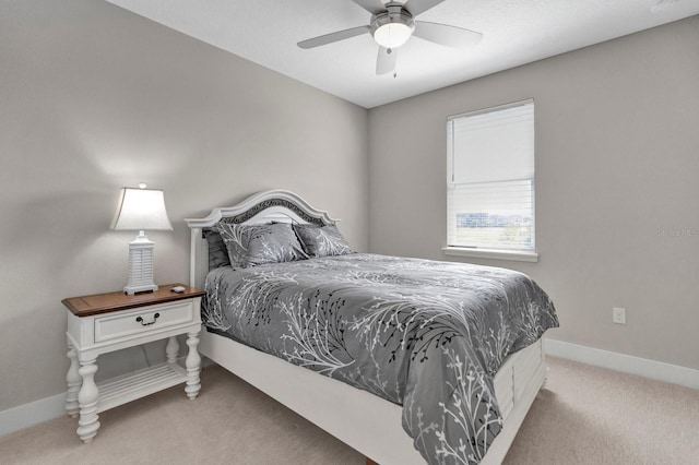 carpeted bedroom with ceiling fan and baseboards