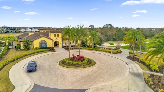 view of front of property featuring curved driveway and stucco siding