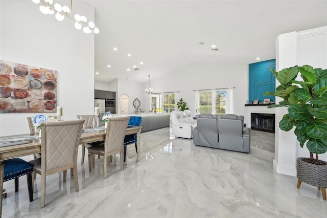 dining space with high vaulted ceiling and an inviting chandelier