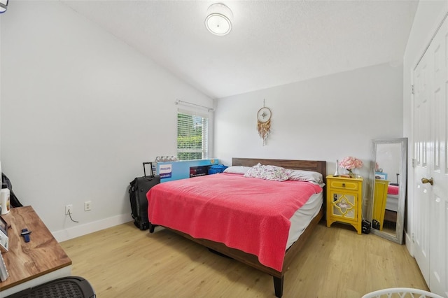 bedroom featuring hardwood / wood-style floors and vaulted ceiling