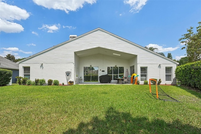 back of property with a patio area and a yard