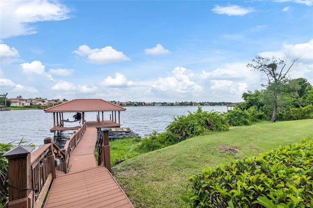 view of dock with a lawn and a water view