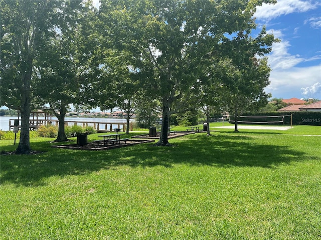 view of home's community featuring volleyball court, a yard, and a water view