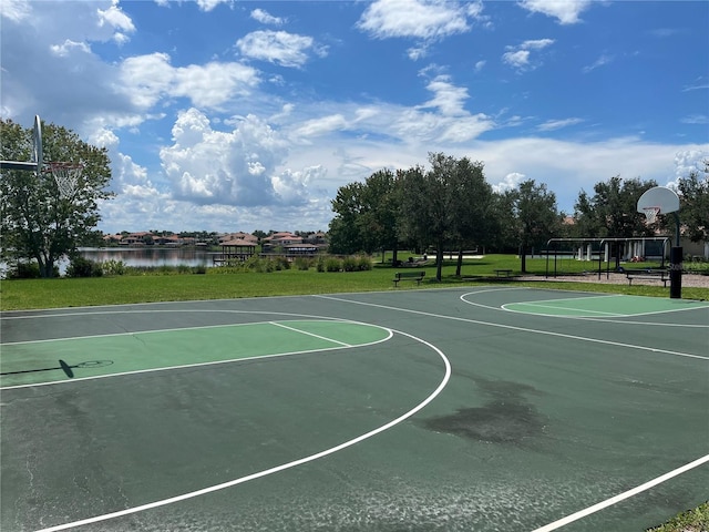 view of sport court with a yard and a water view