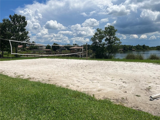 view of home's community with a water view and volleyball court