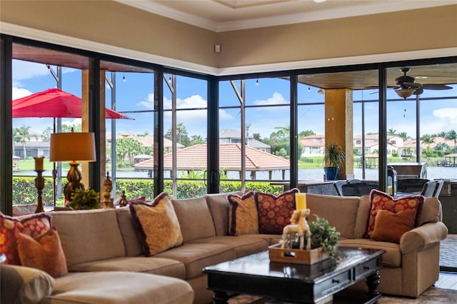 sunroom with ceiling fan, plenty of natural light, and a water view