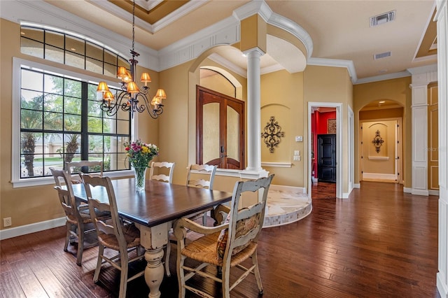 dining space with ornamental molding, dark wood-type flooring, and a notable chandelier