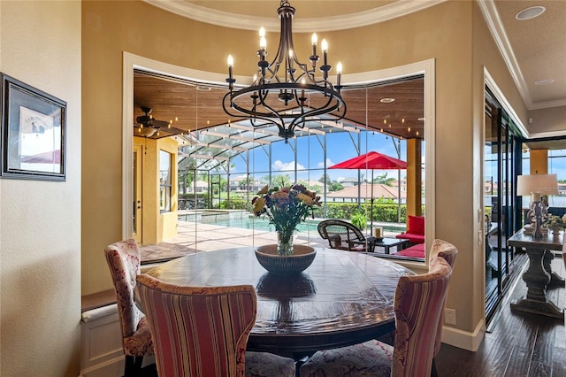 dining area with wood-type flooring, crown molding, and an inviting chandelier