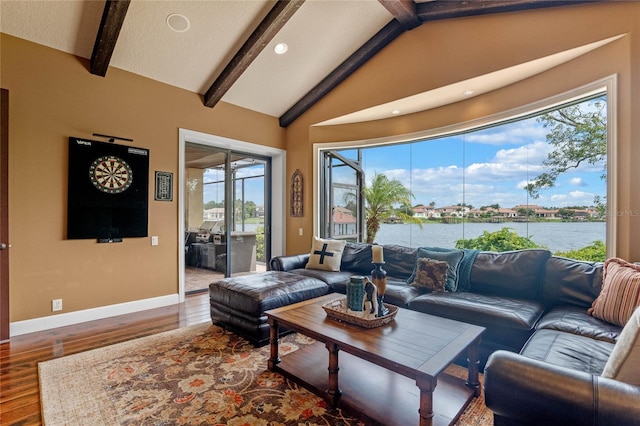 living room featuring vaulted ceiling with beams, a water view, and hardwood / wood-style flooring