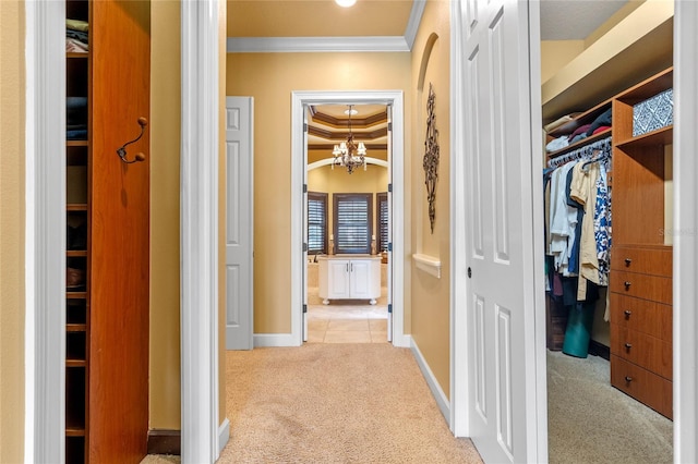 hallway with light colored carpet, an inviting chandelier, and ornamental molding