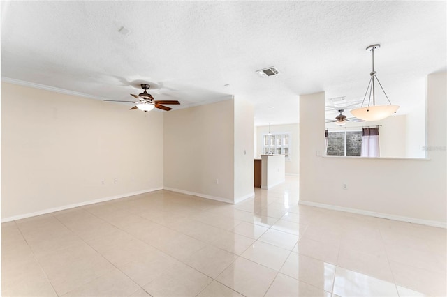 tiled empty room with ceiling fan, ornamental molding, and a textured ceiling