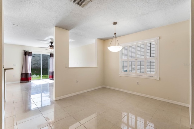 tiled spare room featuring a textured ceiling and ceiling fan