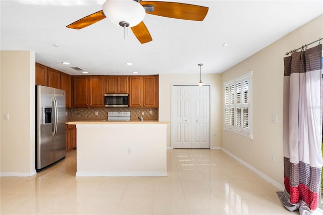 kitchen featuring appliances with stainless steel finishes, tasteful backsplash, ceiling fan, decorative light fixtures, and a center island