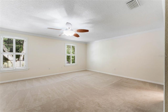 spare room featuring a textured ceiling, light colored carpet, ceiling fan, and ornamental molding