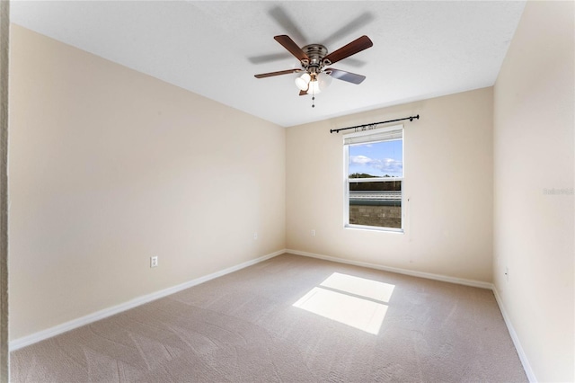 carpeted spare room featuring ceiling fan