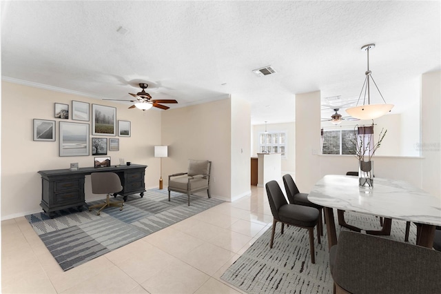 dining space featuring a textured ceiling, ceiling fan, light tile patterned floors, and crown molding