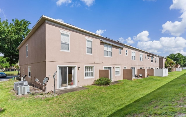 back of property with a lawn and central AC unit