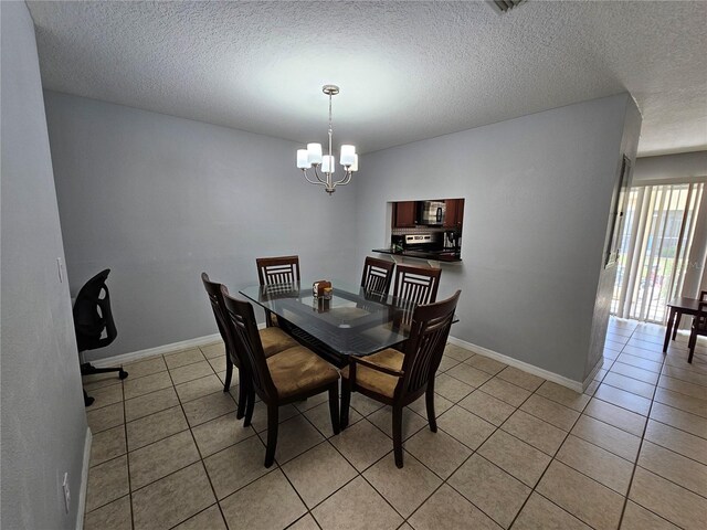 dining space with an inviting chandelier, tile flooring, and a textured ceiling