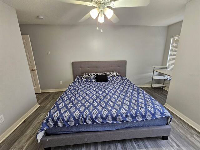 bedroom with ceiling fan and dark wood-type flooring