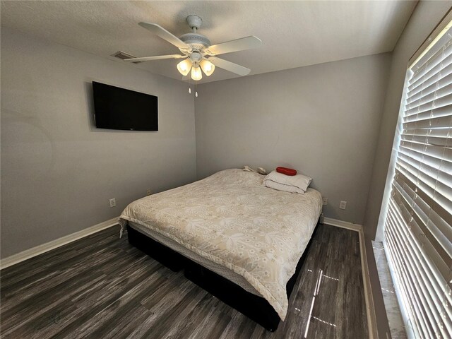 bedroom with dark hardwood / wood-style floors and ceiling fan