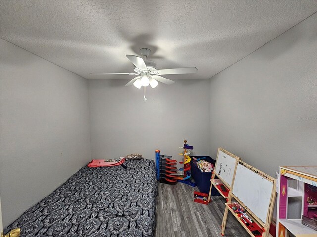 bedroom featuring hardwood / wood-style flooring, ceiling fan, and a textured ceiling