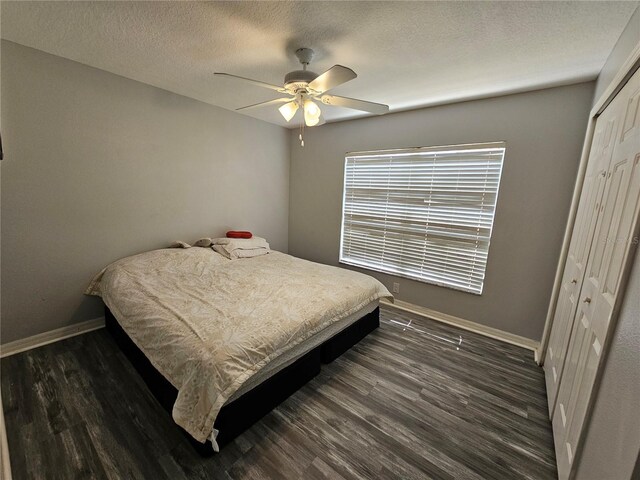 bedroom with ceiling fan, a closet, dark hardwood / wood-style flooring, and a textured ceiling