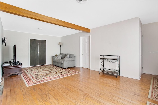 interior space featuring beam ceiling and light wood-type flooring