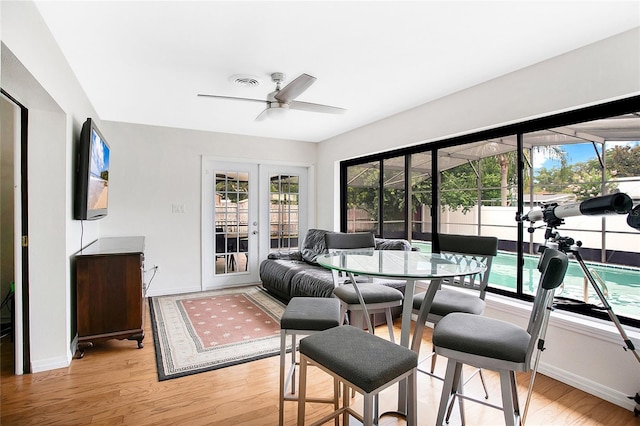 dining area with ceiling fan, french doors, and light wood-type flooring