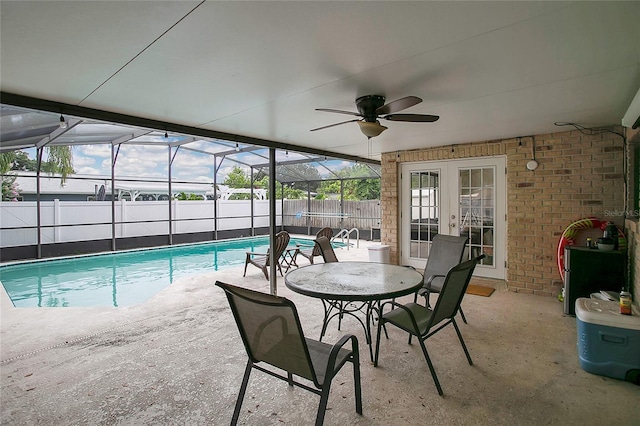 view of swimming pool featuring french doors, a patio, ceiling fan, and a lanai