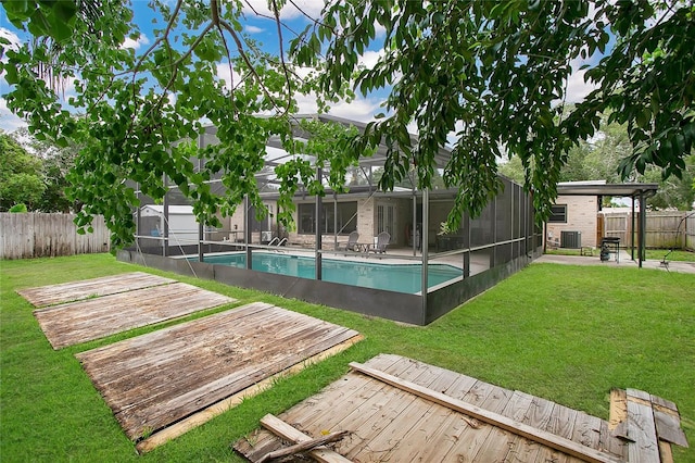 view of swimming pool featuring a lawn, cooling unit, a lanai, and a deck