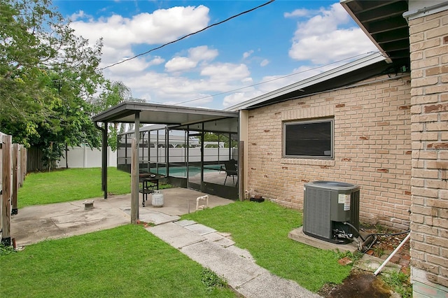 view of patio featuring glass enclosure, a sunroom, central AC unit, and a pool