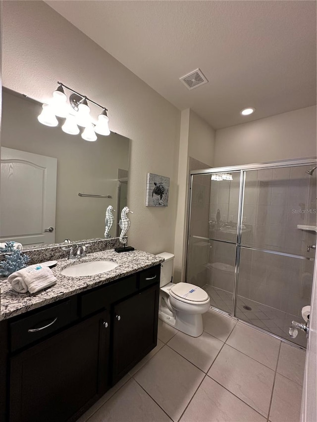 bathroom with tile patterned flooring, vanity, toilet, and an enclosed shower