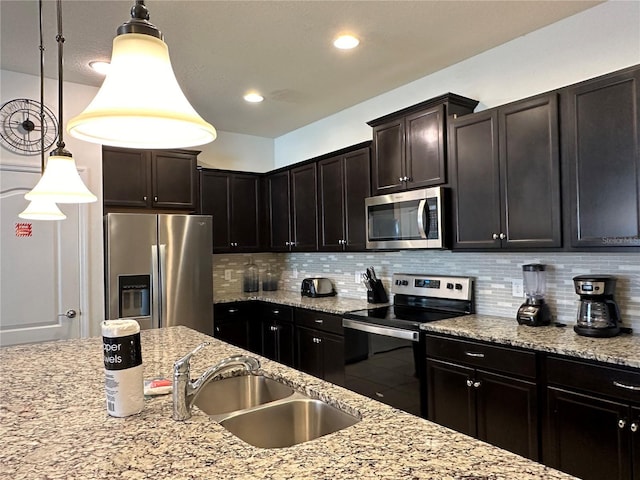 kitchen featuring dark brown cabinetry, sink, hanging light fixtures, stainless steel appliances, and backsplash