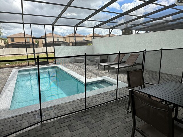 view of pool with a jacuzzi, a lanai, and a patio area