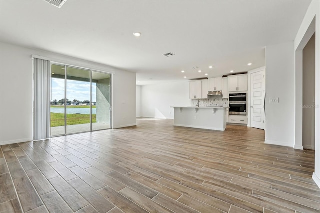 unfurnished living room with light hardwood / wood-style flooring