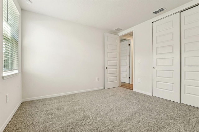 unfurnished bedroom featuring carpet flooring and a closet