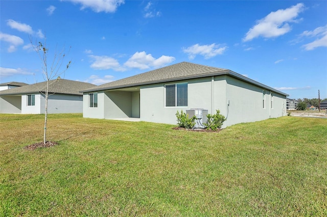 back of house with a yard and central AC