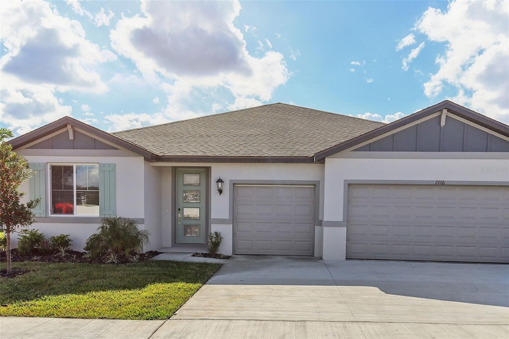 single story home featuring a garage and a front lawn