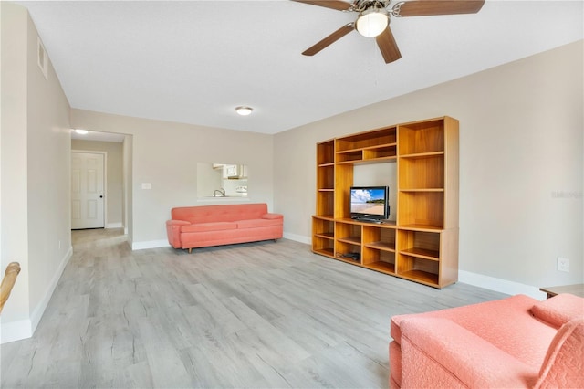 sitting room with light wood-type flooring and ceiling fan