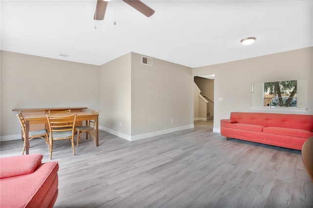 living room featuring ceiling fan and light hardwood / wood-style flooring